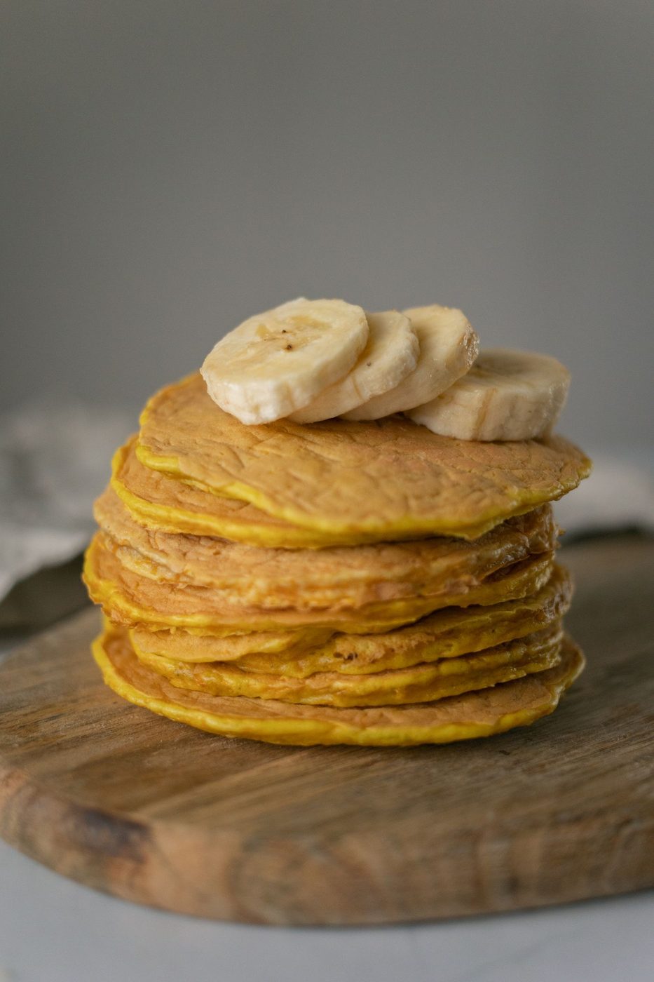 Stabel med små hjemmelagde pannekaker toppet med bananskiver.