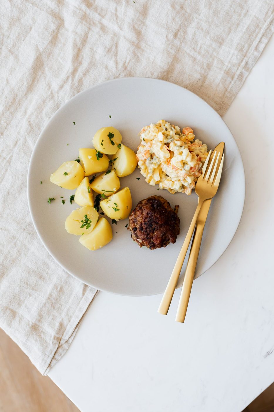 Tallerken med kjøttbolle, kokte poteter og gulrotblanding. Bollen deles i staver før du serverer til de minste.